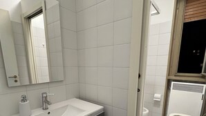 A modern bathroom with a white sink, mirror, and toilet. - Venice House (Venezia)