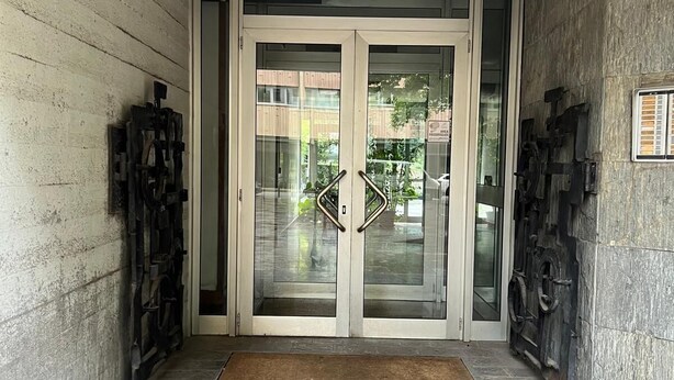 A set of double doors with a glass panel, a doormat, and a stone-tiled entrance. - Venice House (Venezia)
