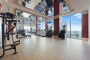 A gym with exercise equipment, large windows, and a city view. - Miami Worldcenter Chic - Rooftop Hot Tub (Miami)
