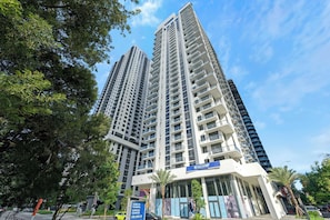A high-rise building with multiple floors, a prominent entrance, and a sign for a nursing training program. - Miami Worldcenter Chic - Rooftop Hot Tub (Miami)