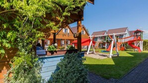 Un edificio in legno con un'area giochi che include scivoli e altalene.