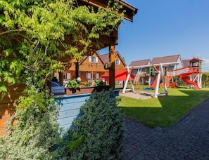 A wooden building with a playground featuring slides and swings. - Two-story Holiday Homes With a Pool (Rewal)
