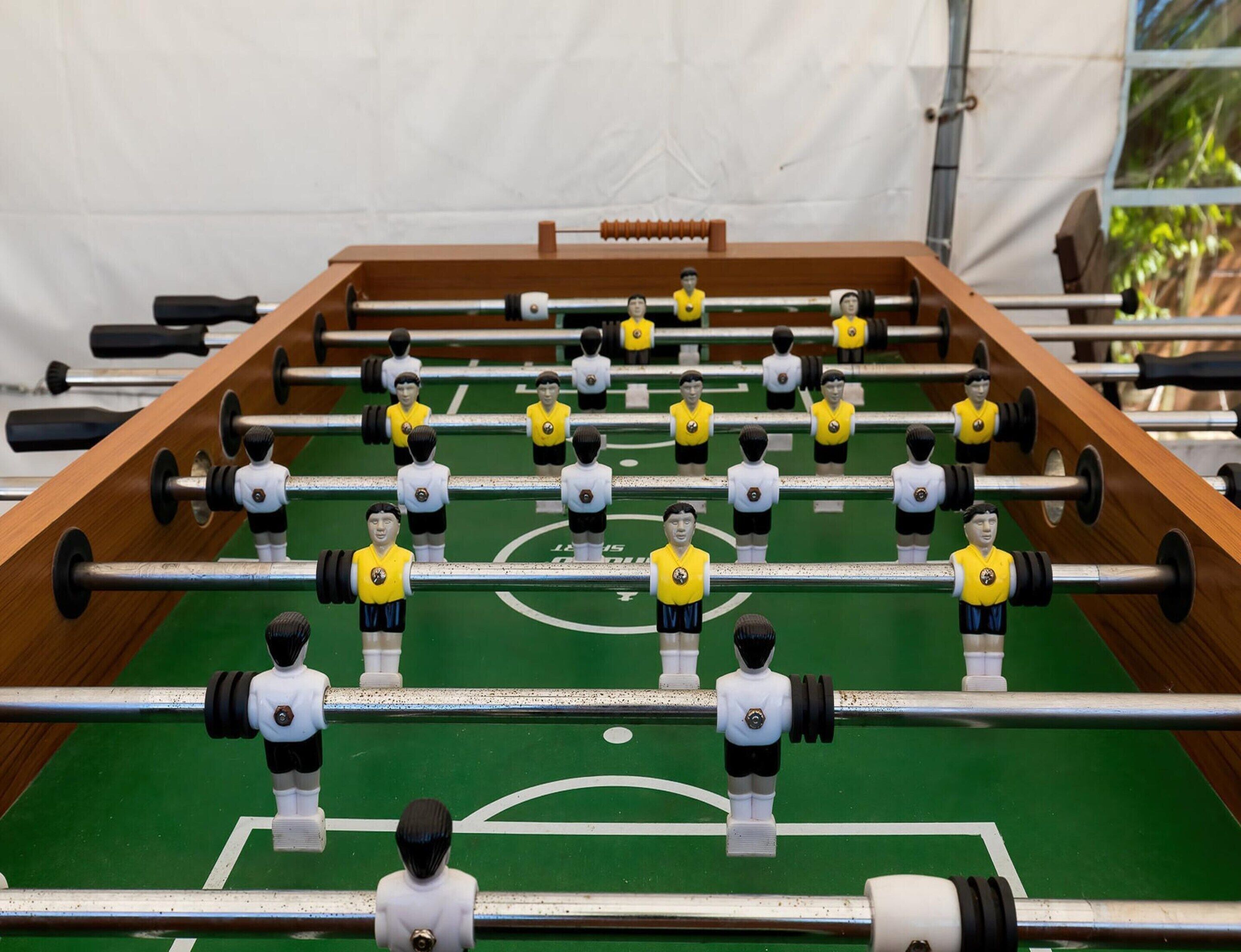 Un tavolo da calcio con diversi giocatori e stecche.