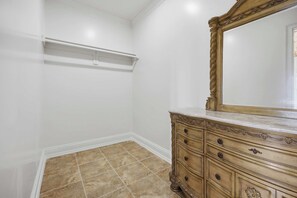 A room with a dresser, a mirror, and a shelf.