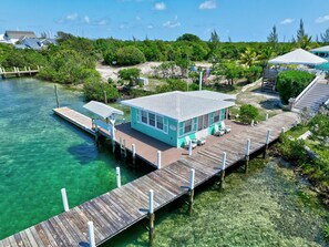 Une propriété située en bord de mer, dotée d’un quai, d’un petit bâtiment avec une zone abritée et offrant une vue dégagée sur la végétation et l’eau environnantes.