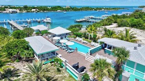 A resort with a swimming pool, lounge chairs, and a dock area. - Turtle Cay Bahamas🤿Blue Marlin🛥️Marina (Green Turtle Cay)