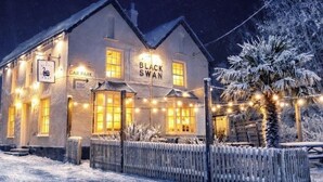 A building with a sign reading 'Black Swan' and 'Car Park' indicating a pub or restaurant. - River View Cottage in the heart of the beautiful Cornish village of Gweek (Gweek)