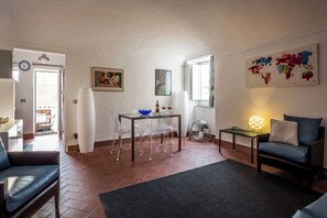 Ein Wohnzimmer mit Sofa, einem Esstisch mit Stühlen, einer Lampe und einer Weltkarte an der Wand.