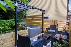 Un espace patio aménagé avec du mobilier d’extérieur, un jacuzzi et une pergola.