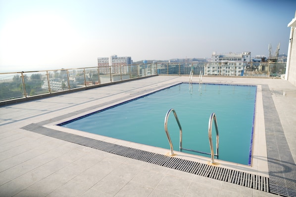 Une piscine sur le toit offrant une vue sur le paysage urbain.