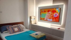 A hotel room with a bed, a TV mounted on the wall, and a bedside table. - Serene 2-bedroom apartment in Medellín perfect for your getaway . Amaizing view (barrio santa fe medellin)