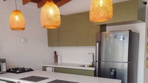 A modern kitchen with a central island, bar stools, pendant lights, and a stainless steel refrigerator. - Serene 2-bedroom apartment in Medellín perfect for your getaway . Amaizing view (barrio santa fe medellin)