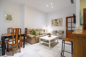 A living room with a sofa, chairs, a coffee table, and a TV. - Córdoba Center Monumental Home (Cordoba)