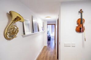 A hallway with a brass tuba, a violin, and framed artwork on the walls. - La Casa de la Musica - A unos pasos de la Mezquita (Cordoba)