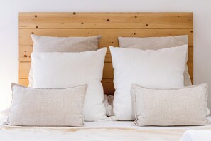 A bed with a wooden headboard and four pillows. - La Casa de la Musica - A unos pasos de la Mezquita (Cordoba)