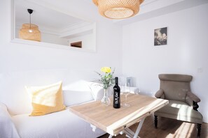 Uma sala de estar moderna com um sofá, uma mesa de madeira, uma cadeira e um lustre.