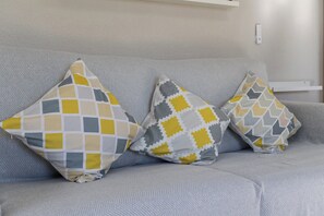 Ein graues Sofa mit drei gemusterten Kissen.