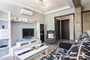 A modern living room with a flat-screen TV, a sofa, a coffee table, and a chair. - Casa Maryna Malaga - Three Bedroom Apartment, Sleeps 5 (Malaga)