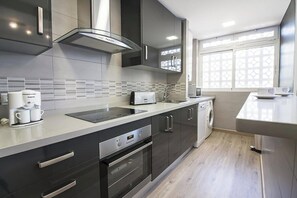 Eine moderne Küche mit integriertem Backofen, einer Kaffeemaschine und einem Geschirrspüler.