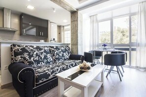 Uma sala de estar moderna com um sofá, uma mesa de jantar e cadeiras.
