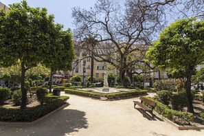 Ein Park mit einem zentralen Brunnen, Bänken und Bäumen.