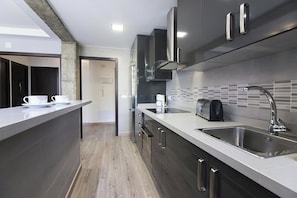 A modern kitchen with stainless steel appliances, a built-in oven, and a large island with a sink. - Casa Maryna Malaga - Three Bedroom Apartment, Sleeps 5 (Malaga)