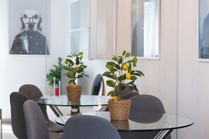 Ein moderner Besprechungsraum mit einem Glastisch, grauen Stühlen und zwei Kübelzitronenbäumen.