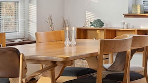 A dining area with a wooden table, chairs, and a disco ball. - 4 Star Holiday Home in Vig (Vig)