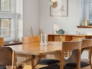 A dining area with a wooden table, chairs, and a disco ball. - 4 Star Holiday Home in Vig (Vig)