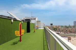 A rooftop terrace with artificial grass, exercise equipment, and a view of the cityscape. - Cosmopolitan Loft & Malaga Beach (Málaga)