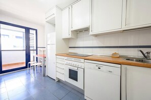 A modern kitchen with white cabinets, a wooden countertop, a built-in oven, and a dishwasher. - Tradiciones Marineras, Puerto y Plaza de Toros (Estepona)