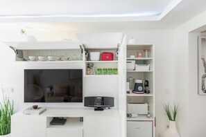 A modern kitchen with built-in appliances, a flat-screen TV, and a white cabinetry system. - Luxury White Summer Benalmadena (Benalmadena)