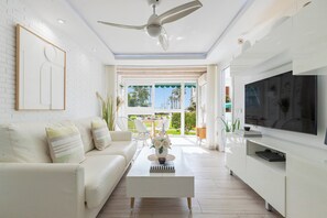 A modern living room with a white sofa, a coffee table, and a flat-screen TV. - Luxury White Summer Benalmadena (Benalmadena)
