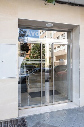 A building entrance with a glass door and a sign above it. - Sierra Nevada Views | Sunny, Spacious & Renovated (Granada)