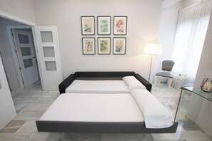 Ein Hotelzimmer mit Bett, Stuhl, Tisch und Lampe.
