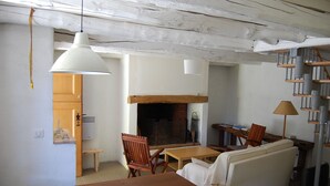 Una sala de estar con chimenea, muebles de madera y un sofá blanco.