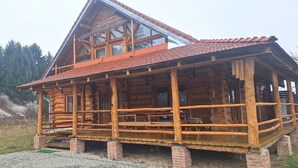 A log cabin with a balcony, wooden exterior, and a sloped roof. - Chalet Rosehip Flowers 4-6 Traveling (Rasnov)