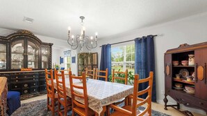 A dining room with a table set for six, surrounded by wooden chairs. - The Plash Pad - 4-bedroom w/Pool in Gulf Shores!! Your Vacation Destination!! (Gulf Shores)