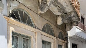 A building with arched windows and a stone staircase leading to the entrance. - Cosy Rooms in a Traditional House in the 'Marble Village' on the Island of Naxos (Naxos)