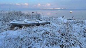 A boat on a snow-covered shore with a calm body of water and distant land in the background. - 4 Star Holiday Home in Follenslev (Follenslev)