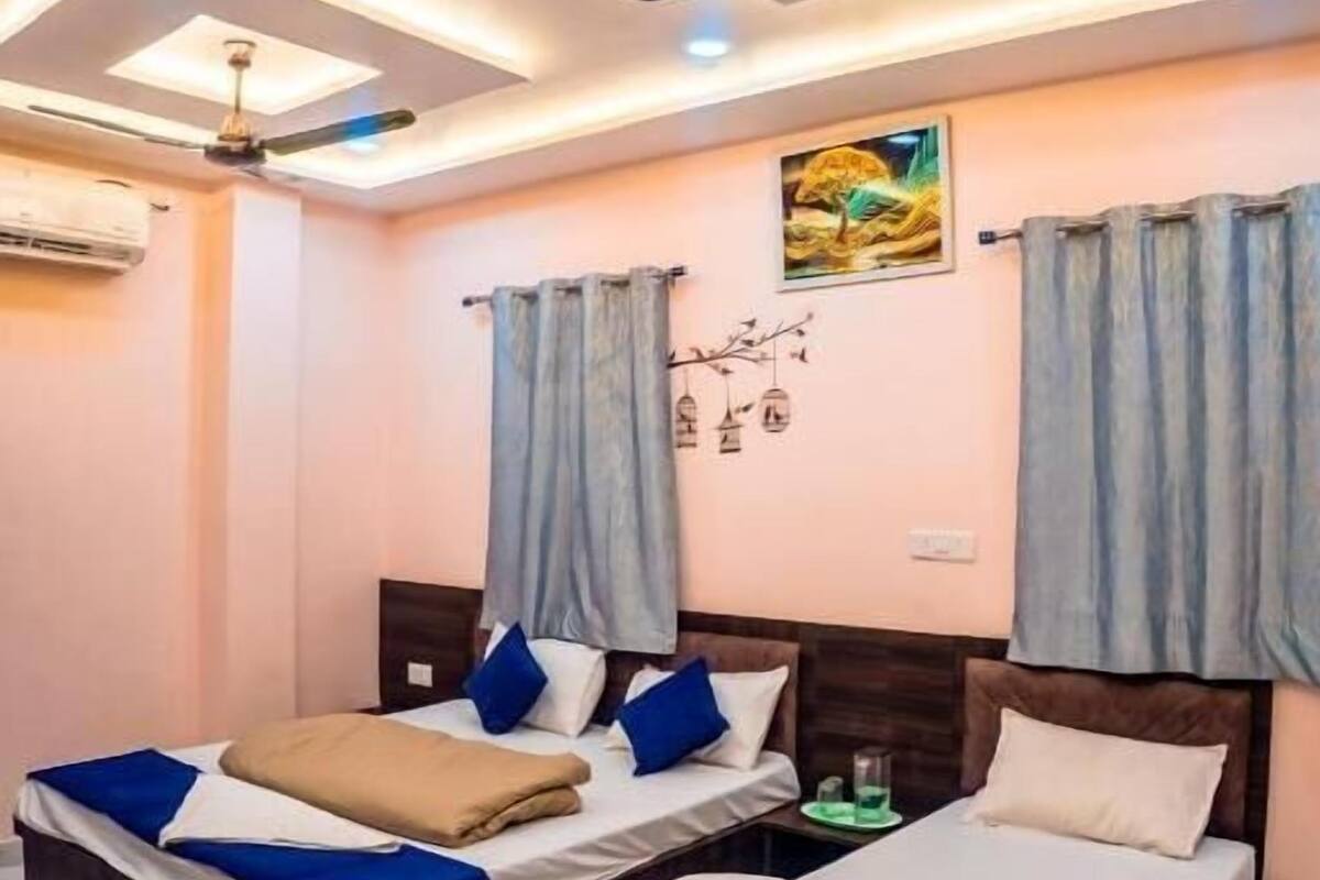 A hotel room with two beds, ceiling fans, recessed lighting, and a mural on the wall.