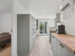 A modern kitchen with a wooden countertop, grey cabinets, and a built-in stove. - 4 Star Holiday Home in Hemmet (Hemmet)