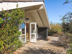 A wooden deck leading to a house with a white exterior and a glass door. - 4 Star Holiday Home in Graested (Graested)