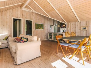 Ein gemütliches Blockhaus-Interieur mit Essbereich, einer Couch und einer Küche.