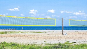 A beach volleyball net with a clear view of the ocean and a sandy beach. - 4 Star Holiday Home in Hejls (Hejls)