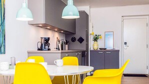 A modern kitchen with a coffee maker, a vase with flowers, and a door with a lock. - 4 Star Holiday Home in Hejls (Hejls)