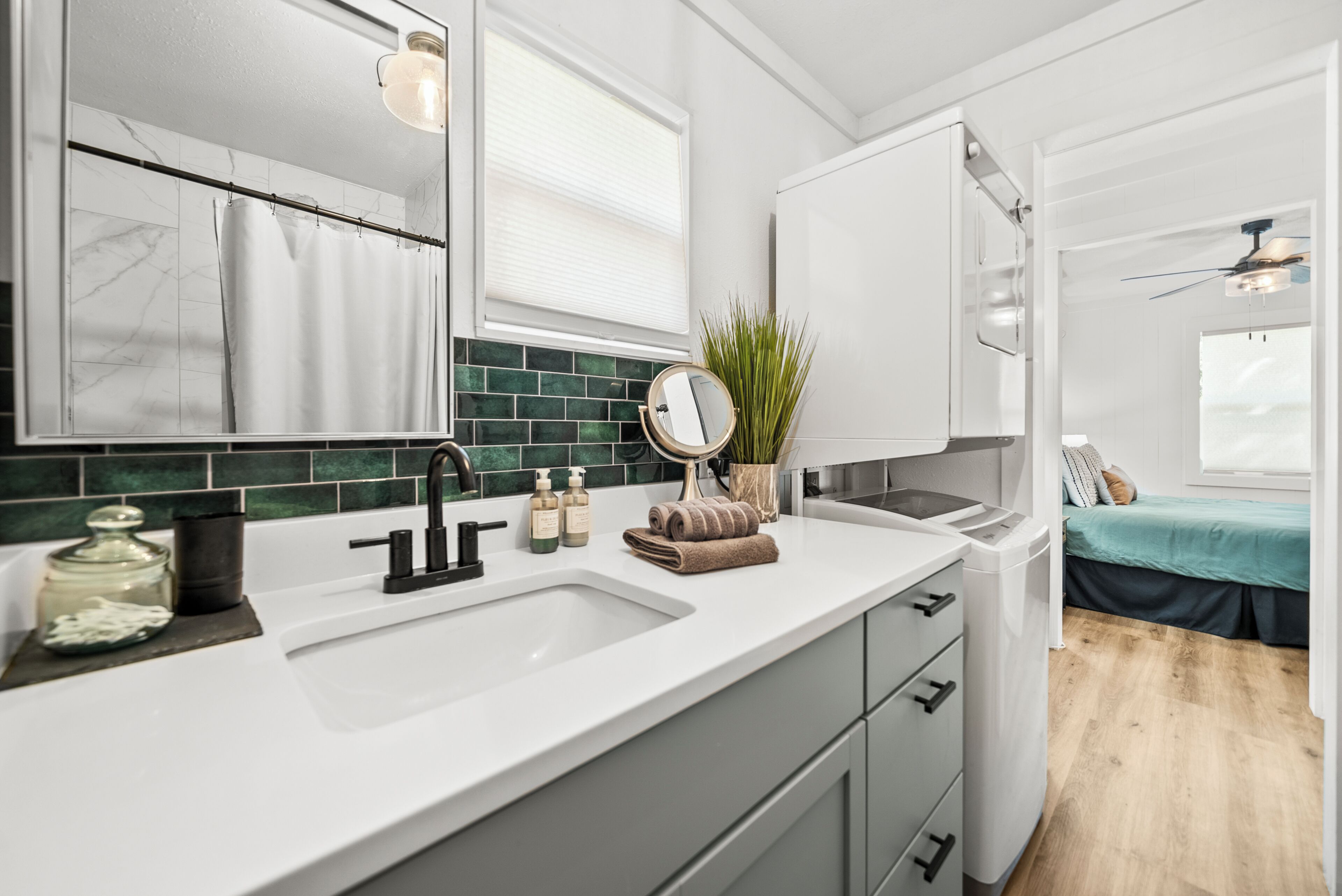 A modern bathroom with a large mirror, a sink, and a shower curtain.
