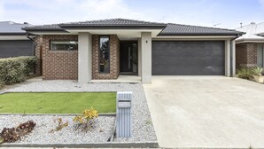 A modern two-story house with a garage, a well-maintained lawn, and a mailbox. - Comfort and Space in Lara's Family Friendly Home (Geelong)