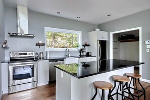 Private kitchen - Chalet Équinoxe Charlevoix with spa | River and mountain views | Massif and trail (Petite-Rivière-Saint-François)