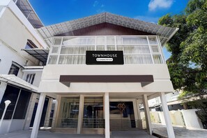 A modern townhouse with a sign indicating it is company-serviced, large windows, and a covered entrance. - Deluxe Keyen Arcade (Kanayannur)